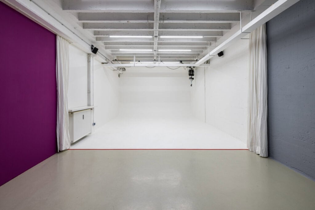 Modernes Fotostudio mit weißen Wänden und Deckenbeleuchtung.