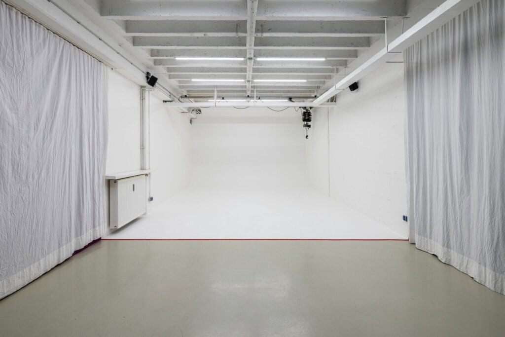 Leeres Fotostudio mit weißen Wänden und Vorhängen.